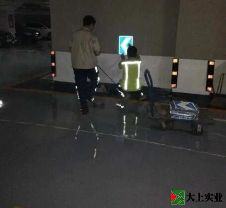 工人正在安裝停車場(chǎng)指示牌